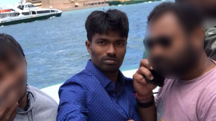 Vigneshwaran Varatharajan is pictured with friends in a selfie with the Sydney Opera House in the background.