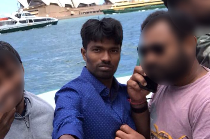 Vigneshwaran Varatharajan is pictured with friends in a selfie with the Sydney Opera House in the background.