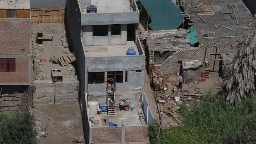 Long aerial shot of houses damaged by earthquake.