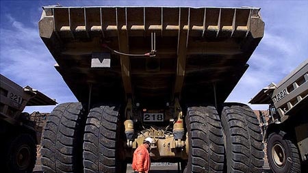 A truck driver walks past a giant mining truck at the largest open pit gold mine in Australia in Kalgoolie.