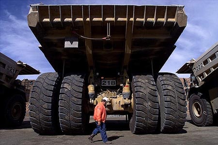 A truck driver walks past a giant mining truck at the largest open pit gold mine in Australia in Kalgoolie.