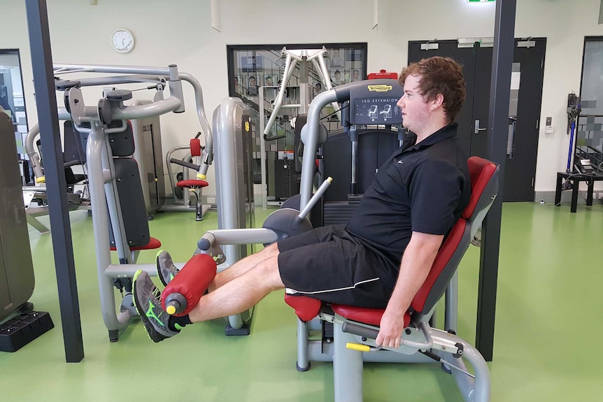 Man exercises on leg extension machine