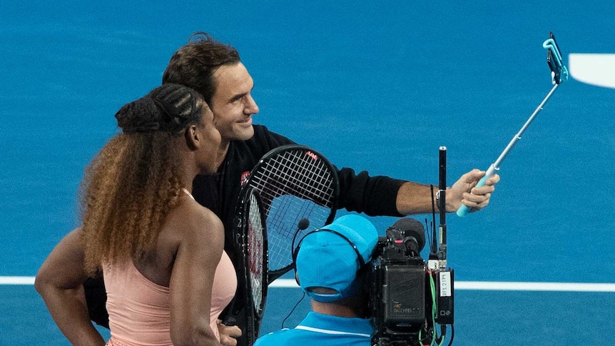 Roger Federer and Serena Williams take a selfie on court