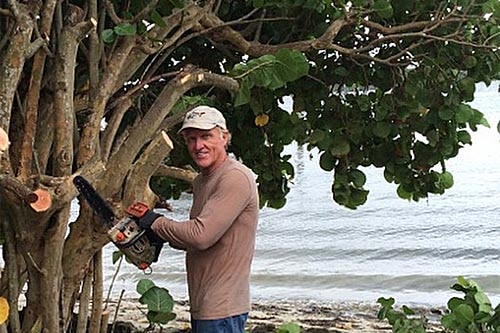Greg Norman holding a chainsaw