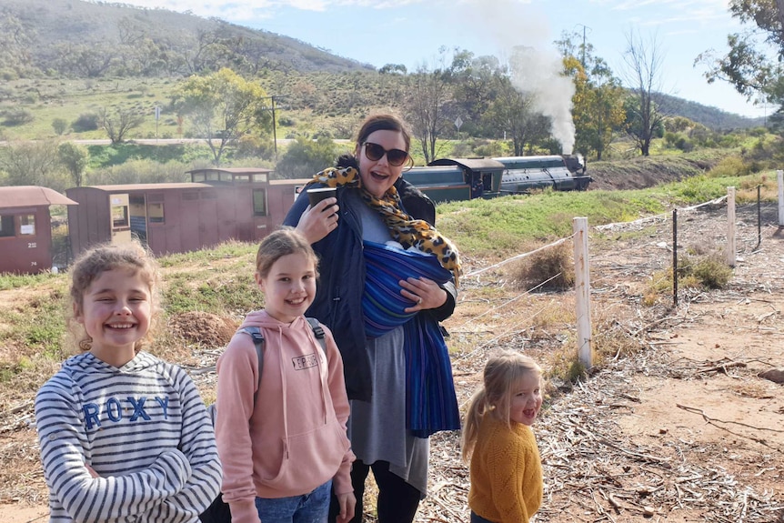 Three young girls with their mum and baby sibling.