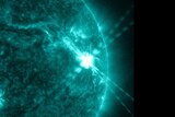 A photo taken by an observatory showing a large solar flare creating a bright flash on the surface of the Sun