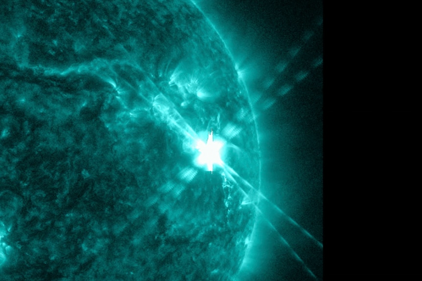 A photo taken by an observatory showing a large solar flare creating a bright flash on the surface of the Sun