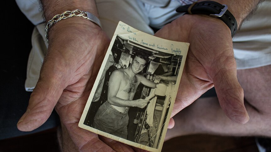 Paddy Boxall holds a photo taken of him during the Vietnam War
