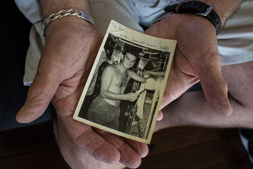 Paddy Boxall holds a photo taken of him during the Vietnam War