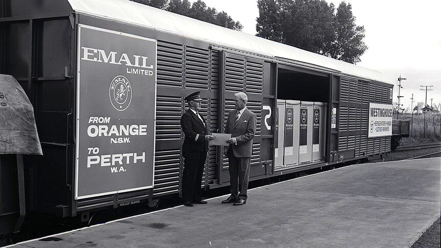 A black and white photograph of a train with the sign email from Orange to Perth on it