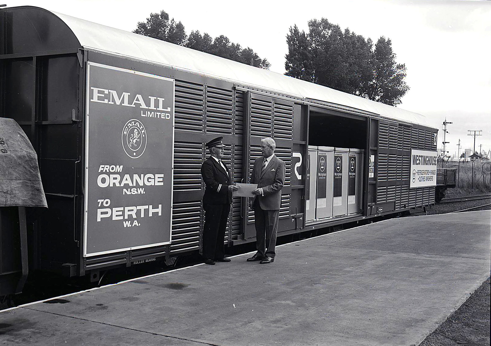 A black and white photograph of a train with the sign email from Orange to Perth on it