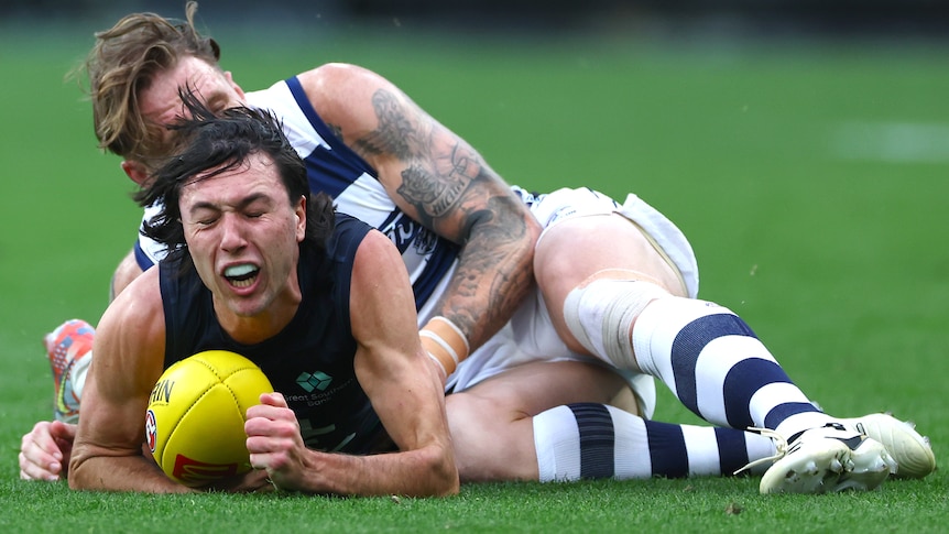 Ollie Hollands tackled by Zach Tuohy during Cats-Blues AFL match.