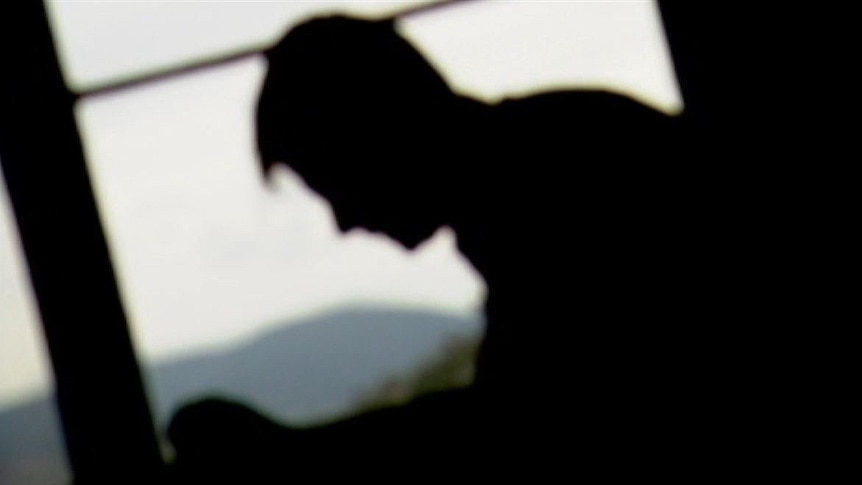 Young male silhouetted against window.