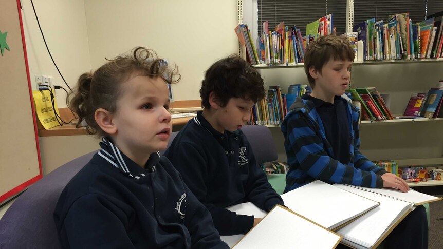 Students reading using braille