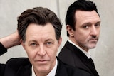 Powderfinger frontman Bernard Fanning and Something For Kate frontman Paul Dempsey pose in black suits.