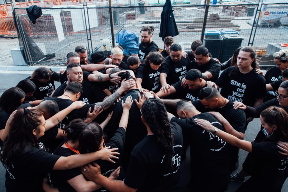 A group session with participants touching hands.