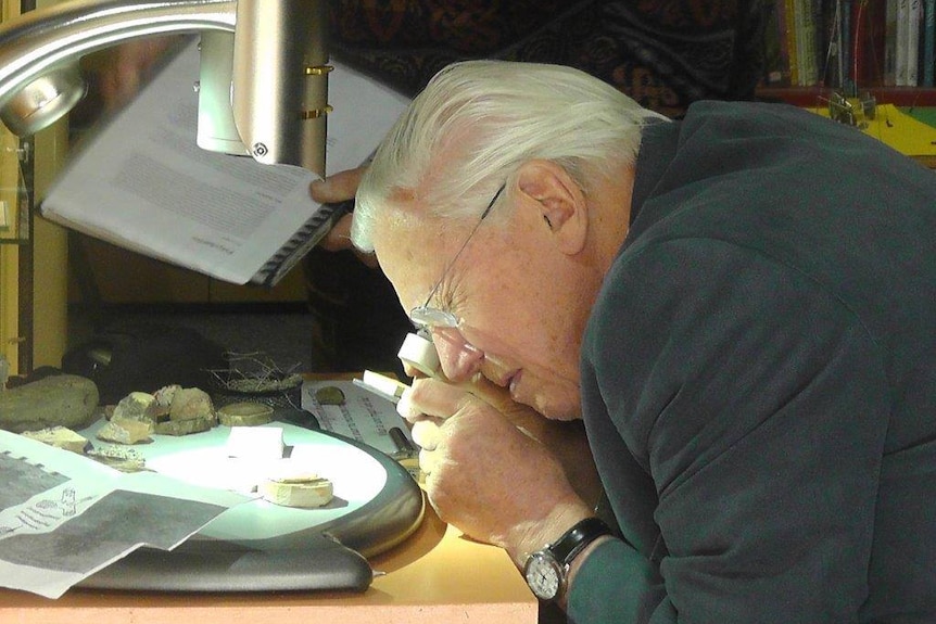 Sir David Attenborough inspecting fossils.
