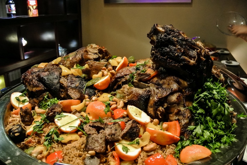 A large Middle Eastern food with rice and meats