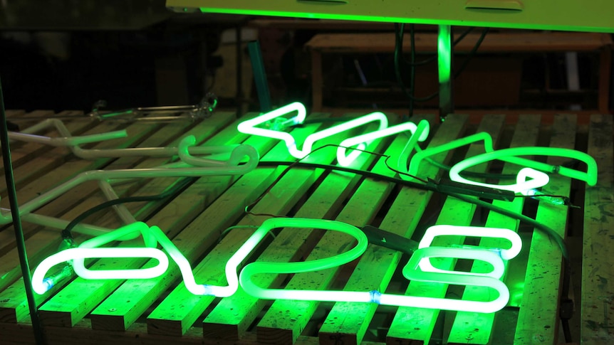 Green neon sign on a wooden workbench