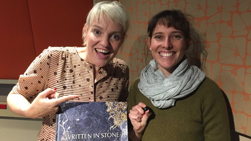 Jacinta Parsons holding the book 'Written In Stone' and Philomena Manifold with a small tektite.
