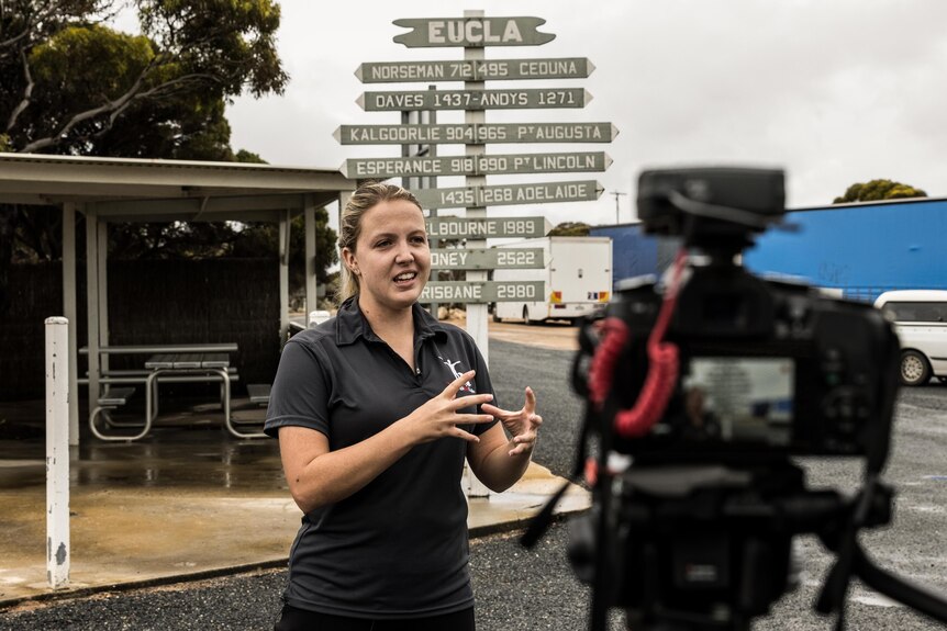 A woman is being filmed for an interview.  