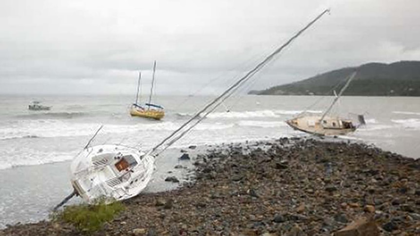Yachts are washed up on rocks near the Airlie Beach lagoon