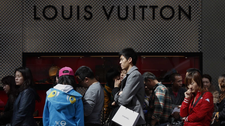 Chinese visitors queue in front of luxury store Louis Vuitton.