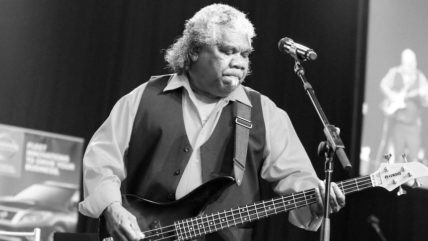 Black and white photo of Uncle "Bimbo" Duncan playing bass guitar on stage.