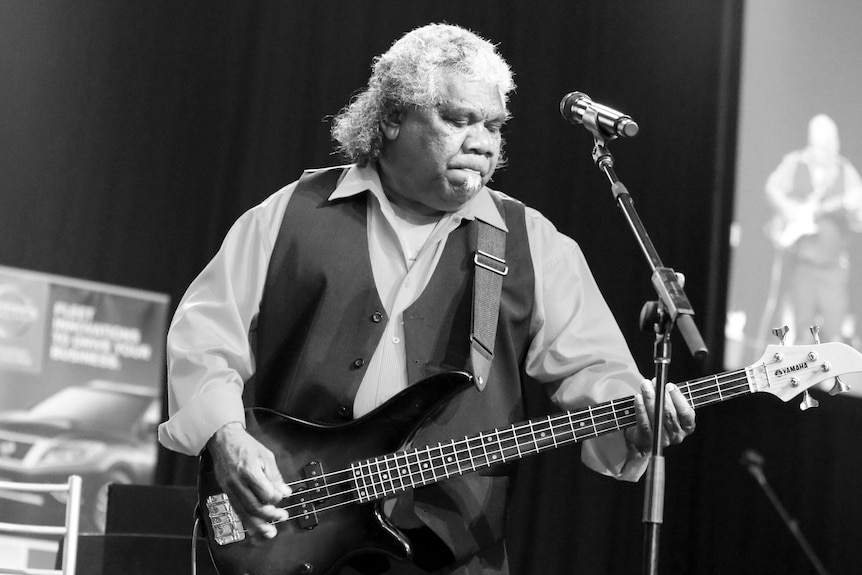 Black and white photo of Uncle "Bimbo" Duncan playing bass guitar on stage.