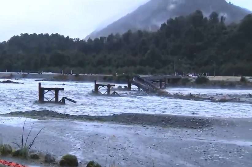 The remains of a bridge that was washed away in a major storm, collapsed into a river