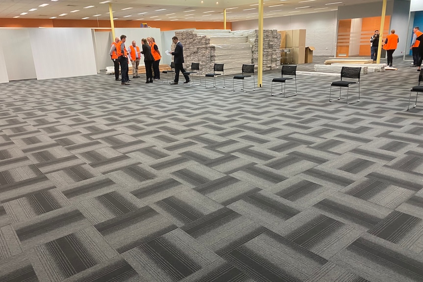 A big room with grey carpet. 