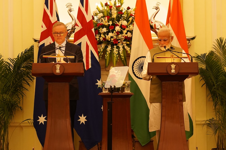 Anthony Albanese (left) and Narendra Modi (right) standing behind lecterns at a joint press conference.
