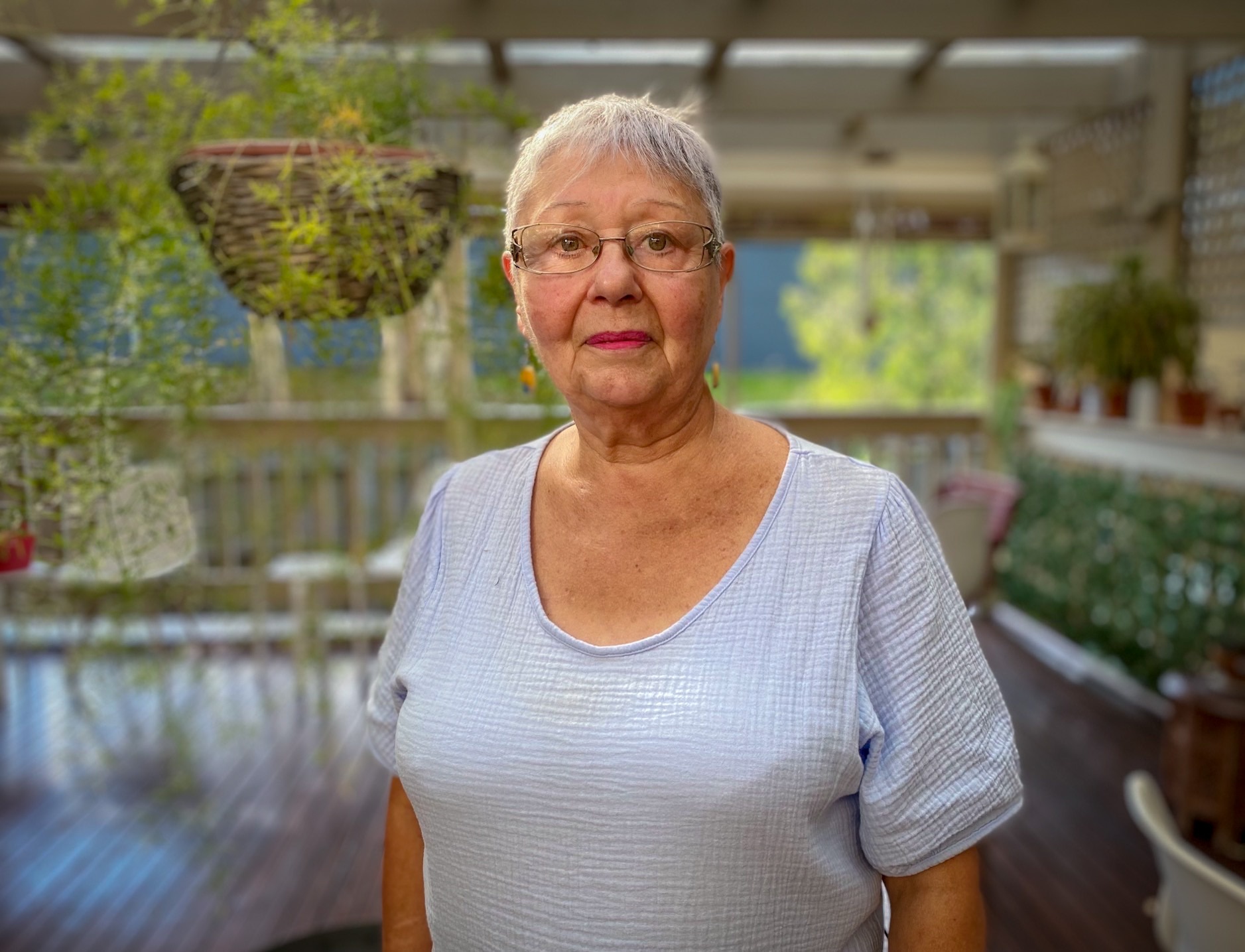Doris standing on a balcony at her home.