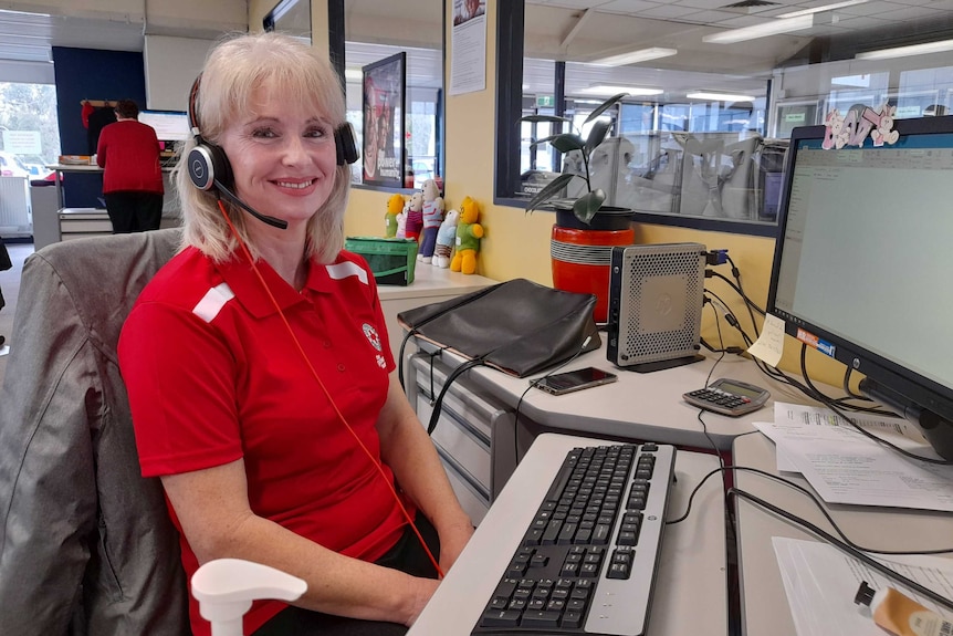 Annette smiles at her desk, wearing a headset.