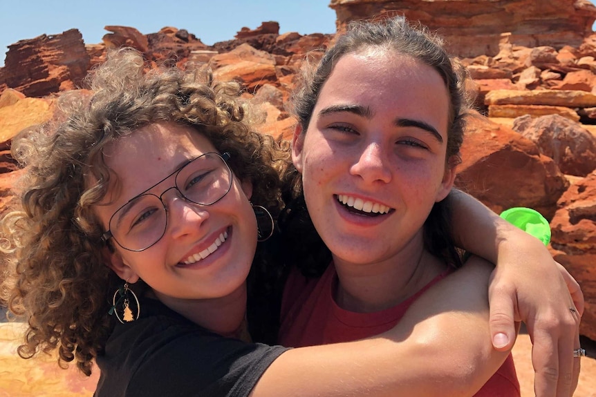 two girls hugging each other outdoors