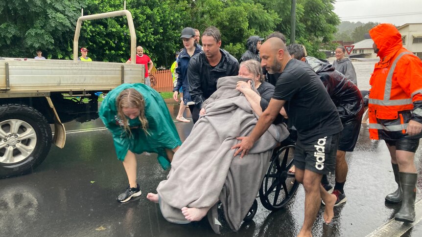woman in wheelchair wheeled out of floodwaters 