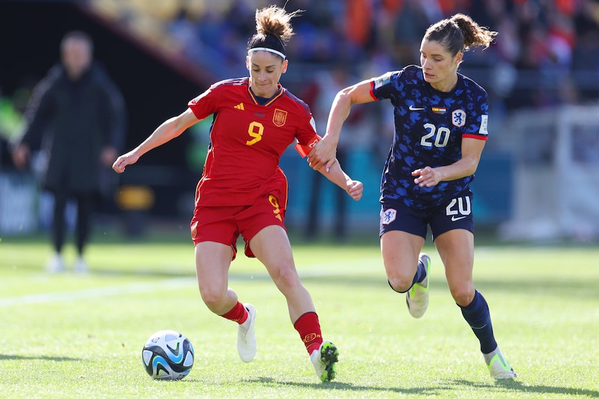 A Spanish player dribbles the ball while being defended against by a Dutch opponent at the Women's World Cup.
