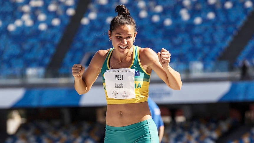 A female athlete with an Australian uniform on celebrates