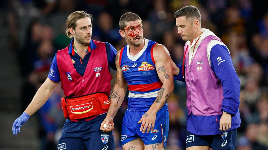Tom Liberatore helped off the ground by doctors