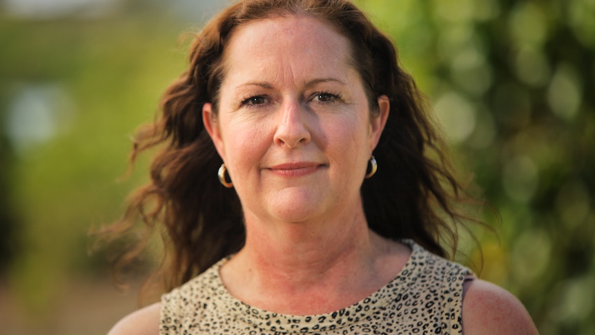 Portrait of a woman with brown curly hair.