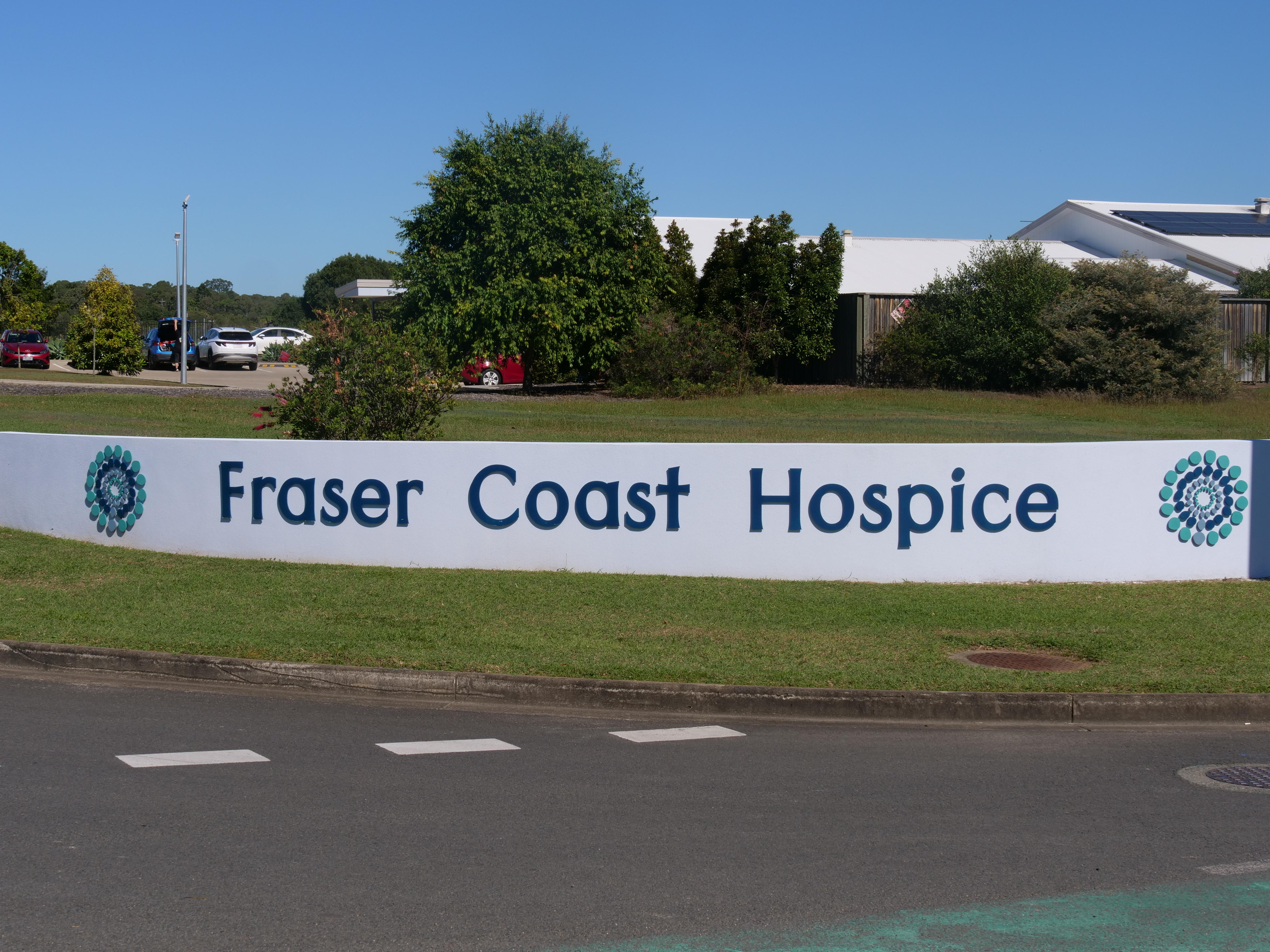 A large sign for a hospice facility stands in front of the service.