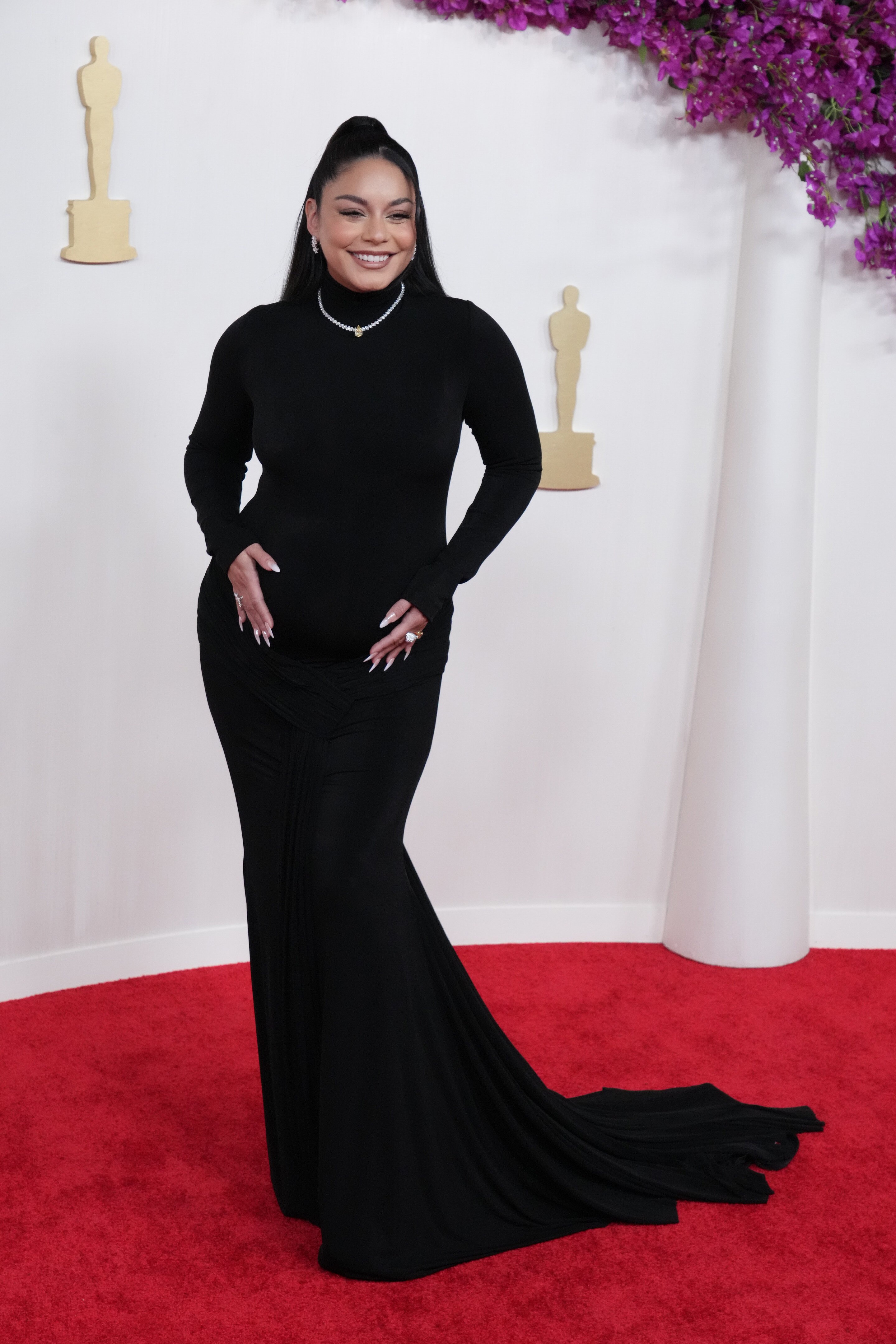 Actress Vanessa Hudgens stands on the red carpet at the Oscars