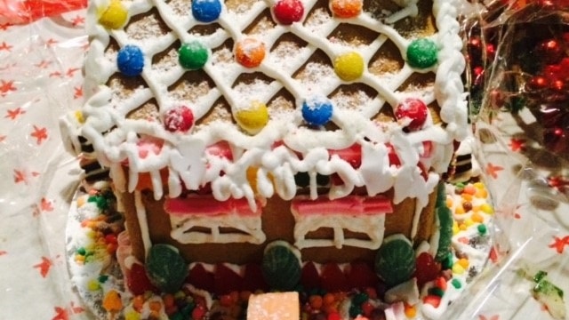 A gingerbread house with lollies and icing sugar 'snow'