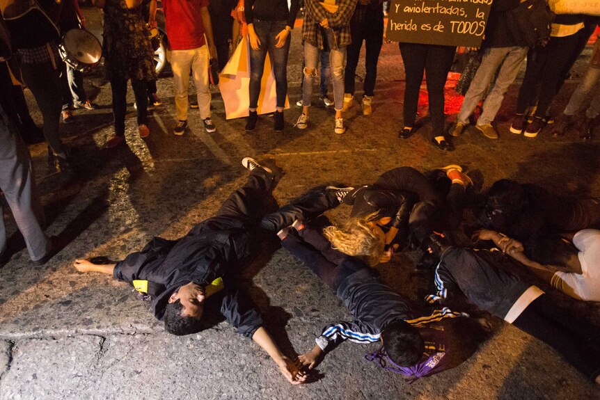 Guatemalans pretend to be dead in a protest demanding justice for fire victims.