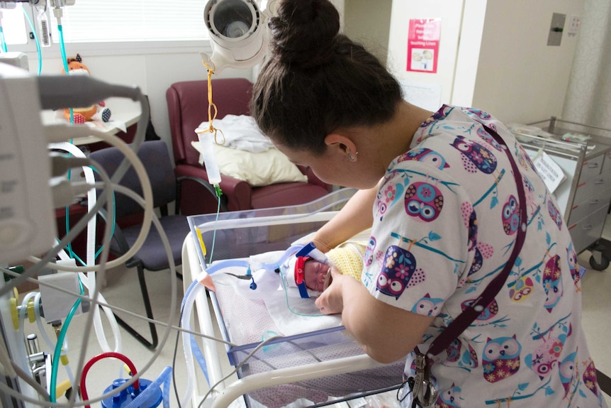 A nurse fixes the breathing tubes for Mary Jane.