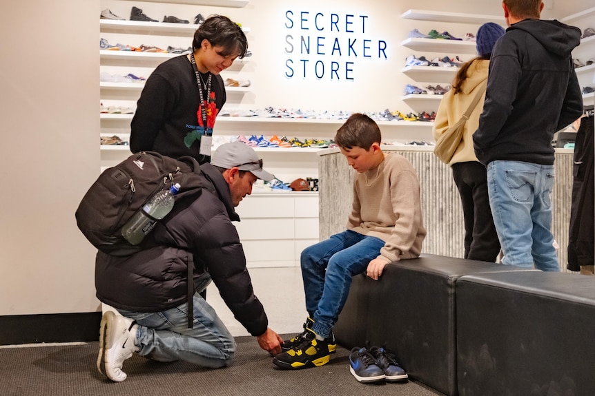 A photo of a kid trying on sneakers.