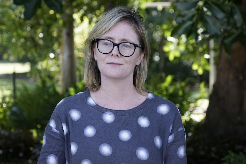 Head shot of Kirsty Howey, wearing glasses, with a park behind her.
