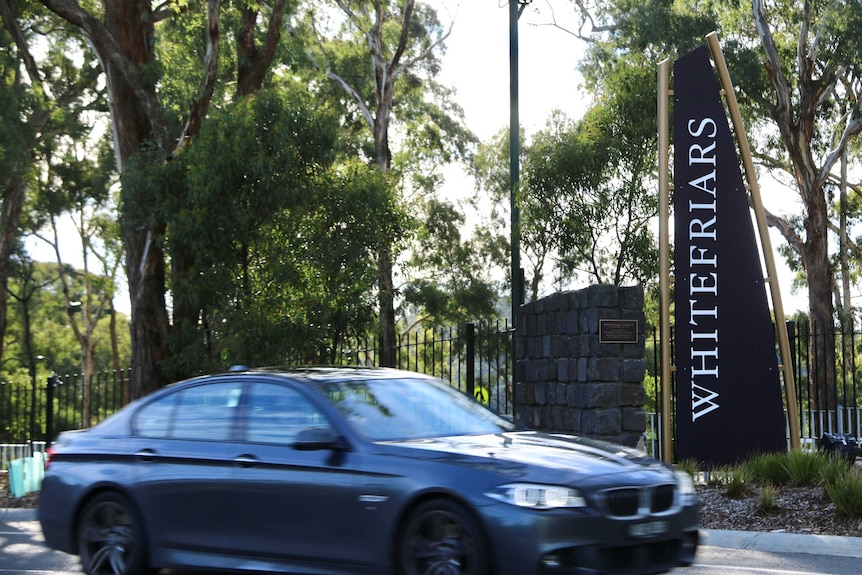 A car drives past a sign outside Whitefriars College.