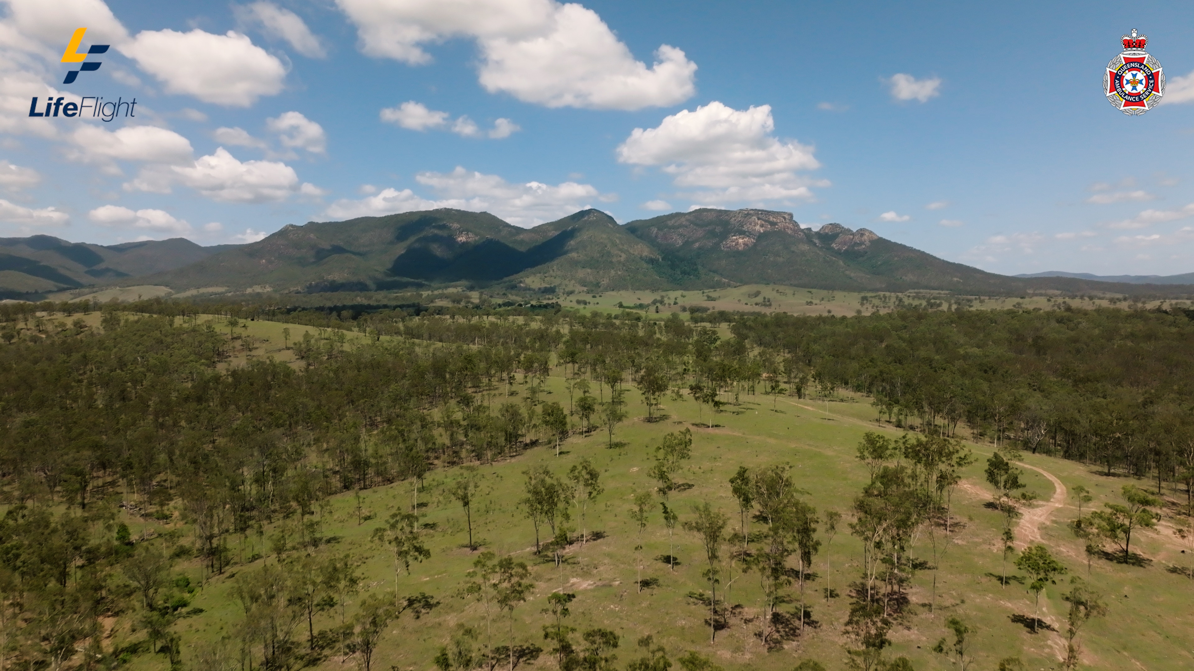 Uma cordilheira surge atrás de uma paisagem ondulada.