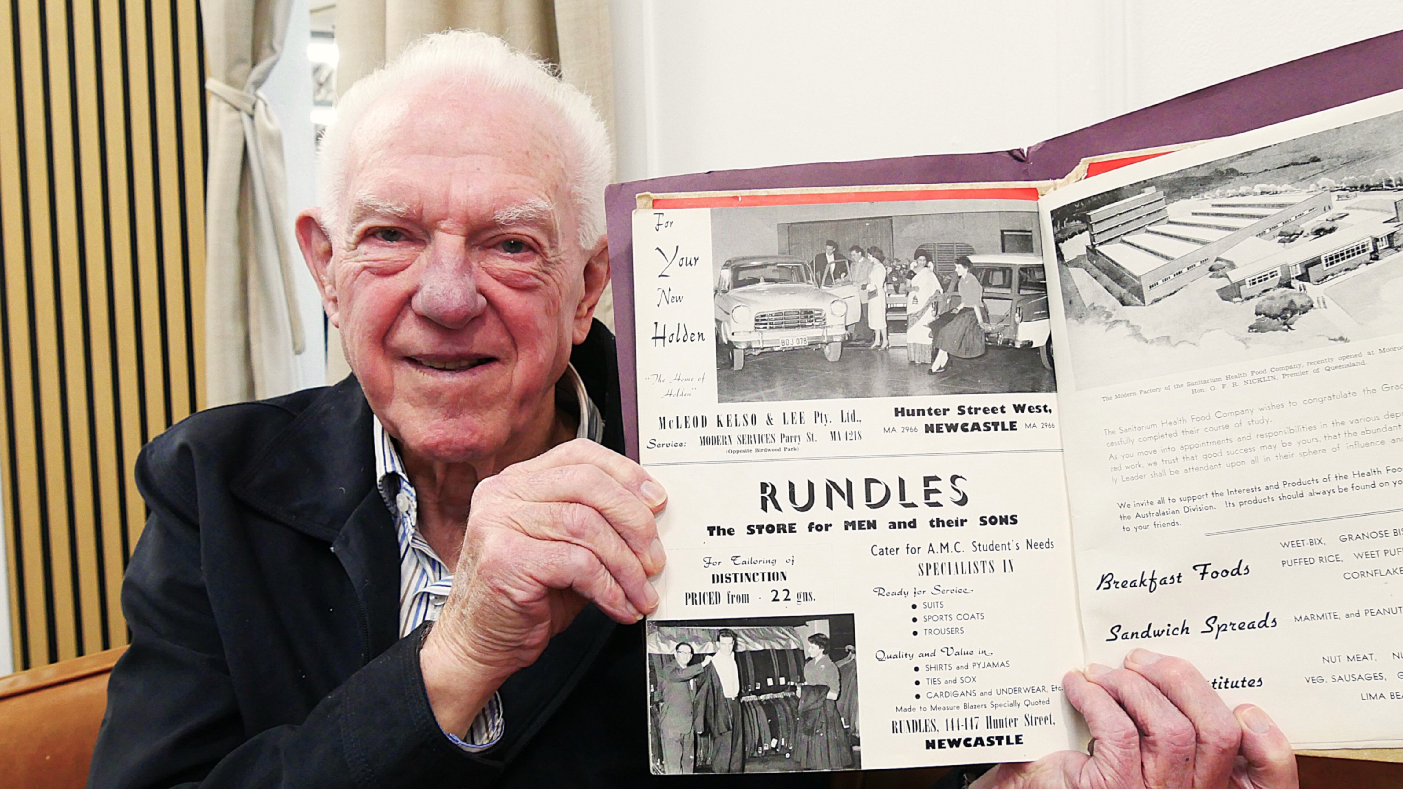 Ross Willis holding a magazine of him modelling for Rundles